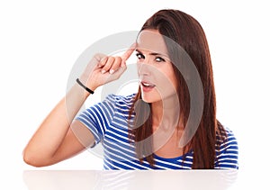 Reflective young woman pointing to her forehead