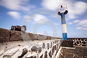 Reflex camera on stone wall with a small lighthouse