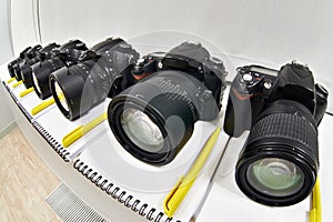 Reflex digital cameras with notepad in photoschool close-up