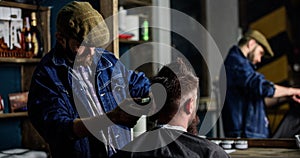 Reflexion of barber with clipper trimming hair of client. Hipster client getting haircut. Hipster lifestyle concept