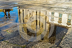 Reflexion of the catholic church in puddle