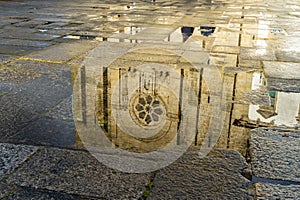 Reflexion of the catholic church in puddle in Porto