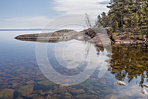 Reflexion in lake of rocky coast.