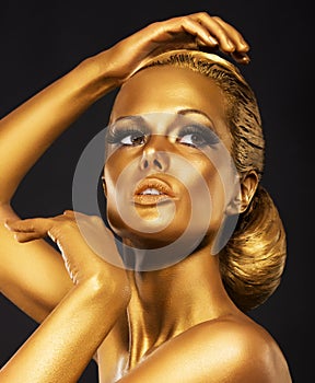 Reflexion. Portrait of Glossy Woman with Bright Golden Makeup. Bronze Bodypaint