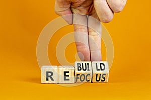 Refocus and rebuild symbol. Businessman turns cubes and changes the word `refocus` to `rebuild`. Beautiful orange table, orang