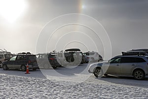 The refraction of the light forms a halo around the sun above a ski field car park