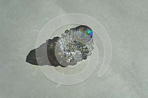 Refraction and reflection of light casts shade and shadow on white paper background. Sparkling glass crystals refract harsh photo