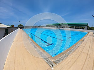 Refraction of sunlight in swimming pool water in swimming club - ruffle water pool with blue sky.