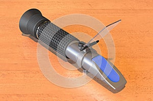 Refractometer on the wooden table. 3D rendering