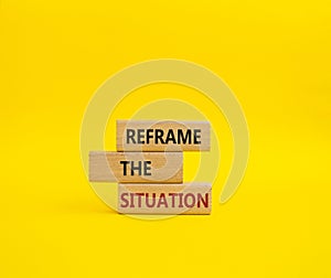 Reframe the situation symbol. Concept words Reframe the situation on wooden blocks. Beautiful yellow background. Business concept