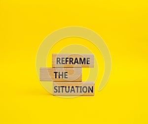 Reframe the situation symbol. Concept words Reframe the situation on wooden blocks. Beautiful yellow background. Business concept