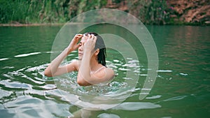 Refreshed lady walking fjord water. Relaxed woman touching wet hair clear lake