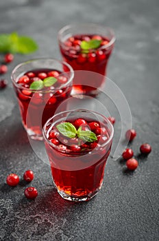 Refreshing cocktail with cranberry and mint on dark concrete background