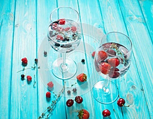 Refreshing cocktail with vodka martini with ice and berries on wood table