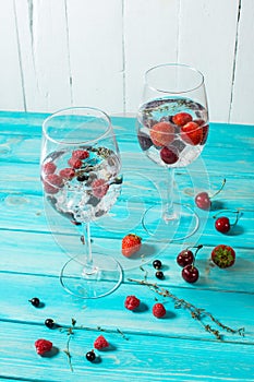 Refreshing cocktail with vodka martini with ice and berries on wood table