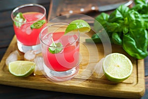 Refreshing cold strawberry cocktail with lime slices and basil s