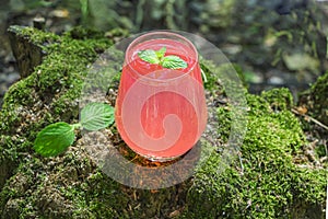 Refreshing cool summer lemonade from strawberry, raspberries, grapefruit or red currants. Pink cocktail drink in glass outdors on