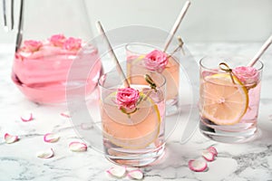 Refreshing drink with lemon and rose on marble table