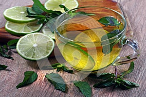 Refreshing drink with mint and lime. a cup of mint tea with lime on a wooden table.