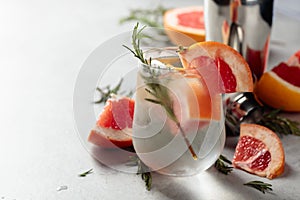 Refreshing drink with natural ice, grapefruit, and rosemary in a frozen glass