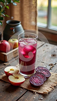 Refreshing glass of apple and beet juice with ice on rustic wooden table
