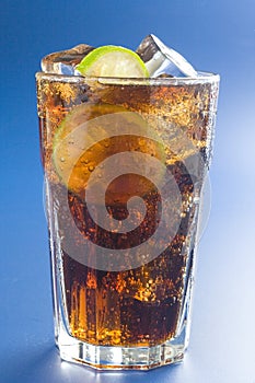 Refreshing glass of cola with lemon and ice