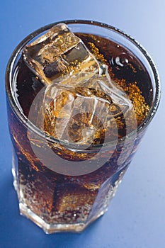 Refreshing glass of cola with lemon and ice