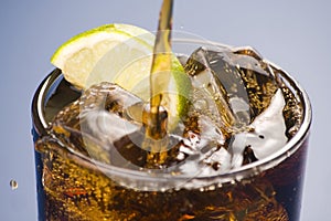 Refreshing glass of cola with lemon and ice