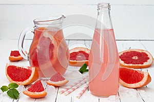 Refreshing grapefruit cocktail with mint over old vintage wooden table.