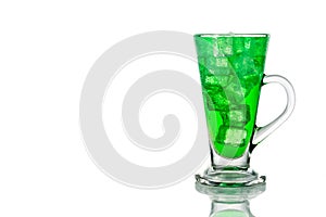 Refreshing green fizzy soft drink with ice in transparent glass