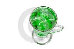 Refreshing green fizzy soft drink with ice in transperant glass