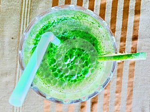 Refreshing Green Juice on Table with Glass and Straw