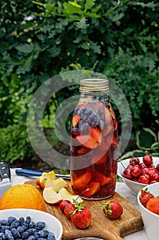 Refreshing homemade lemonade or sangria punch with citrus fruits and organic berries. Summer cocktail with ice and fruit juice
