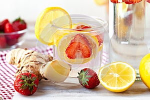 Refreshing homemade sparkling lemonade with fresh strawberry, lemon, ice and ginger. Healthy cold drink, low calories. Tasty cool