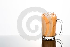 Refreshing ice cold tea with milk in transparent glass