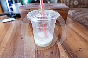 A Refreshing Ice Drink that has been drunk lies on a Wooden Table