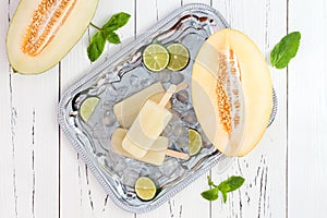 Refreshing ice pops over silver tray. Lime, honeydew white sangria paletas - popsicles. Top view