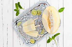 Refreshing ice pops over silver tray. Lime, honeydew white sangria paletas - popsicles. Top view photo