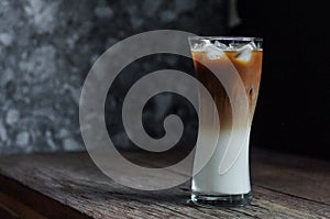 Refreshing iced coffee latte on wooden table in restaurant and c