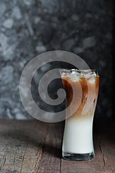 Refreshing iced coffee latte on wooden table in restaurant and c