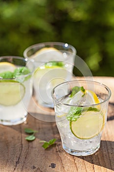 Refreshing lemonade drink with mint lime lemon in garden