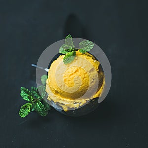 Refreshing Mango sorbet ice-cream scoop in scooper, square crop