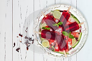 Refreshing mexican style ice pops - watermelon, hibiscus, lime paletas - ice pops - popsicles, served on vintage silver tray photo