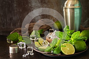Refreshing Mojito cocktail making. Mint, lime, ice ingredients and bar utensils