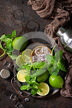 Refreshing Mojito cocktail making. Mint, lime, ice ingredients and bar utensils