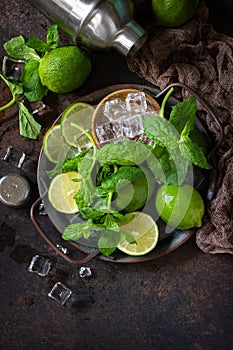 Refreshing Mojito cocktail making. Mint, lime, ice ingredients and bar utensils