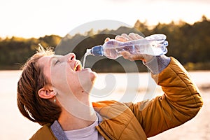 Refreshing Moment: Young Caucasian Girl Savoring Water Outdoors