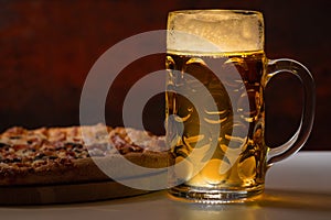 Refreshing mug of chilled beer with pizza