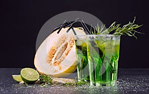 Refreshing non-alcohol drinks. Cut melon and green cocktails on a black background. Sweet drinks with liquor, lime and tarragon.