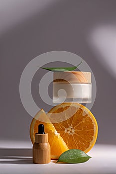 Refreshing orange citrus fruit beauty treatment for skincare. Moisturizer face cream and beauty serum in bamboo dropper
